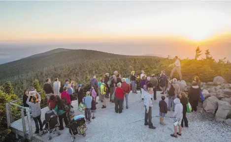  ?? PHOTOS: DARIO AYALA/ THE GAZETTE ?? Astronomy tour guide Nicolas Ploix (top right, on rock) speaks to tourists as the sun sets over the observator­y at the Mont Mégantic provincial park.