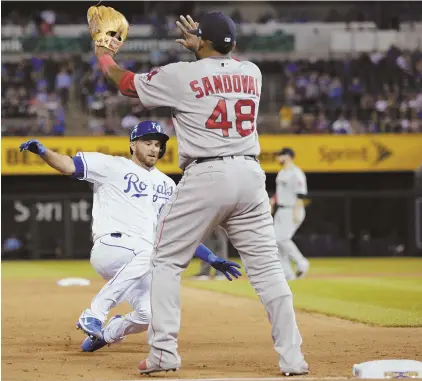  ?? AP PHOTO ?? TOO LATE: Drew Butera slides in with a triple as third baseman Pablo Sandoval waits for the throw in the seventh inning of the Sox’ loss to the Royals last night.