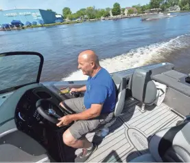  ?? PHOTOS BY MARK HOFFMAN/USA TODAY NETWORK ?? Tim Doberstein drives a boat with a 300 G2 Evinrude on June 3. BRP Inc. will no longer make the outboard motors.