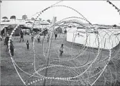  ?? AP ?? Displaced South Sudanese walk at the camp in Wau. More than 200,000 people still shelter in the camps.