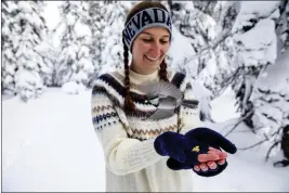  ?? JENNIFER KENT — UNIVERSITY OF NEVADA, RENO, VIA AP ?? University of Nevada, Reno, student Michelle Werdann feeds a wild mountain chickadee pine nuts at Chickadee Ridge in Mount Rose Meadows, Nevada, on Jan. 6.