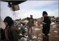  ?? (AP/Rodrigo Abd) ?? People wait for a truck to unload garbage that they can search for valuables to sell on Friday at the municipal dump in Santa Rosa, Argentina.