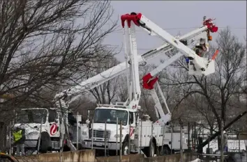  ?? Julio Cortez/Associated Press ?? Utility workers from Xcel Energy work on power lines Feb. 28 near a home destroyed by the Smokehouse Creek Fire in Stinnett, Texas. The utility provider Xcel Energy said Thursday that its facilities appeared to have played a role in igniting a massive wildfire in the Texas Panhandle that grew to the largest blaze in state history.