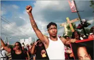  ?? AP PHOTO BY NUCCIO DINUZZO ?? On Sunday, July 15, protesters march in the South Shore neighborho­od of Chicago following the fatal shooting of a barber by a Chicago police officer in the 7100 block of South Chappel Ave., in Chicago.