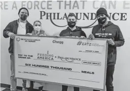  ?? PHOTOS FROM BRENNEN CREER ?? Zach Ertz, left, Julie Ertz, second from left, and Athlete's Corner co-founders Brennen Creer, middle, and Kelenna Azubuike hold up a charity check to mark their 600,000 meals donated to Philadelph­ia food banks in 2021.