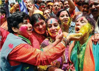  ?? — PTI ?? BJP workers celebrate with colours outside party office in Bengaluru on Tuesday.