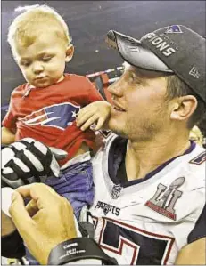  ?? AP ?? Nate Solder holds up his son, Hudson, who is fighting kidney cancer but was able to see his dad win Super Bowl 51 with Pats.