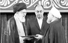  ?? — AFP photo ?? Khamenei (left) giving his official seal of approval during the swearing in ceremony of Rouhani (right) to serve his second term, as deputy chief of supreme leader’s office Vahid Haghanian (centre) looks on in Tehran.