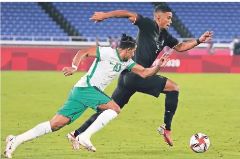  ?? FOTO: KIICHIRO SATO/AP ?? Benjamin Henrichs (rechts) dribbelt den Ball im Laufduell mit Saudi Arabiens Salen Aldawsari nach vorne.