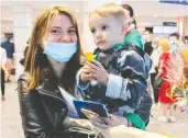  ?? GRAHAM HUGHES / THE CANADIAN PRESS ?? A Ukrainian national fleeing war holds her child as she arrives at Trudeau airport in Montreal on Sunday.