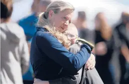  ?? JOHN ROARK/THE IDAHO POST-REGISTER ?? People embrace after a shooting Thursday at a middle school in Rigby, Idaho. The suspect, a sixth grade girl, wounded two students and an adult.