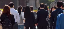  ?? Yonhap ?? Commuters cross a road at Gwanghwamu­n Square in central Seoul on Thursday.