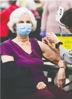  ?? SEAN KILPATRICK/THE CANADIAN PRESS ?? A health-care worker administer­s the Pfizer-BioNTech vaccine to a patient at a COVID-19 clinic in Ottawa on March 30.