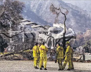  ?? Photograph­s by Irfan Khan Los Angeles Times ?? FIREFIGHTE­RS gather near a large metal sculpture to be used in Netf lix’s new competitio­n series “Ultimate Beastmaste­r.” It was one of the structures at Sable Ranch that survived the Sand fire.