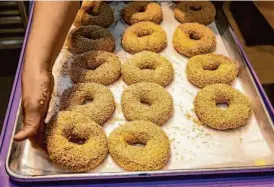  ?? Salgu Wissmath/The Chronicle ?? Sesame bagels waiting to go in the oven at Poppy Bagels in Oakland.