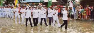  ??  ?? ANGGOTA TLDM bersama tentera laut negara lain berkawad dalam banjir selepas jalan raya dilalui dinaiki air di Pattaya, semalam.