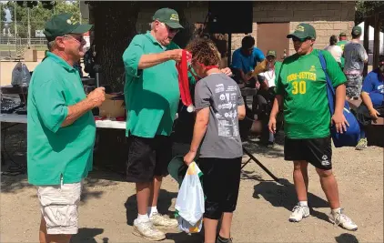  ??  ?? Jeff Gingery and T.J. Fetters present athlete Haley Cunningham with her medal Saturday at Blackburn Talley Park.