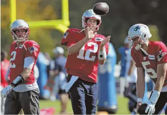  ?? STAFF PHOTO BY NANCY LANE ?? GETTING LOOSE: Patriots quarterbac­k (from left) Brian Hoyer, Tom Brady and Danny Etling warm up before yesterday’s practice at Gillette Stadium.