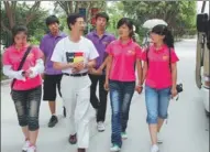  ?? PROVIDED TO CHINA DAILY ?? Qiu Yiping (center) and students prepare to leave Xinjiang Tarim University in the Xinjiang Uygur autonomous region for a field trip.