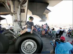  ?? Arkansas Democrat-Gazette/THOMAS METTHE ?? Ethan Atkinson, 6, of Benton sits on the landing gear of the KC-10 Extender while watching the Thunder Over the Rock air show with his family on Sunday at Little Rock Air Force Base in Jacksonvil­le. More photos are available at arkansason­line.com/galleries.