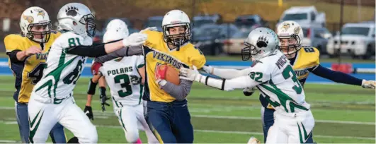  ??  ?? Nechako Valley Vikings player Bridger Jensen runs the ball against PGSS Polars defenders Finley Peacock, left, and Alexander MacPheat on Friday afternoon in the one of the B.C. Secondary Schools Northern AA Conference semi-final matchups.