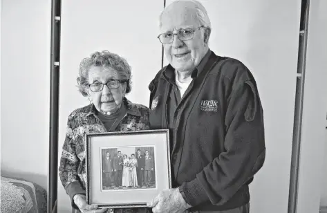  ?? DESIREE ANSTEY/JOURNAL PIONEER ?? Ethel and Austin Pendergast hold a picture taken following their wedding at St. Paul’s Catholic Parish Church in Summerside in 1950. With them in this wedding photo are Eddie Pendergast, left, Austin and Ethel, Mary Deighan, Tom Pendergast and Charlie Deighan.