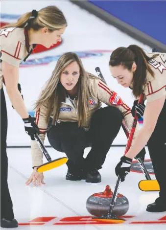  ?? JEFF MCINTOSH/THE CANADIAN PRESS ?? Ontario skip Rachel Homan, centre, ground out a 7-6 win over Chelsea Carey and Wild Card 1 on Friday afternoon to tighten her rink's grip on first place.