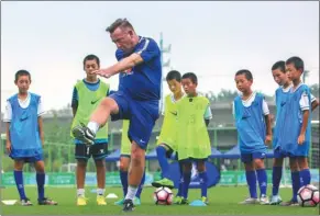  ?? PROVIDED TO CHINA DAILY ?? A trainer from Chelsea Football Club in the United Kingdom coaches teenagers at a Beijing soccer training center in July 2017.