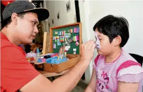  ?? — KEVIN TAN/The Star ?? Abdul Hakam Rahmad painting the face of a child for a photoshoot earlier this year.