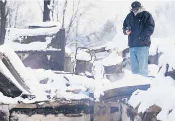  ?? JACK DEMPSEY/AP ?? Daniel Peers looks at what remains of his brother’s burned homes Saturday in snowy Louisville, Colorado.