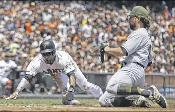  ?? BEN MARGOT / ASSOCIATED PRESS ?? Eduardo Nunez slides to score on a wild pitch by Braves pitcher R.A. Dickey (right) in the first inning of the Giants’ 7-1 victory Sunday in San Francisco.