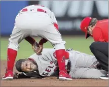  ?? Mike Carlson Associated Press ?? ANGELS MANAGER Joe Maddon, top, checks on Dexter Fowler, who stepped awkwardly on second base in the second inning.