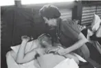  ?? AP ?? A nurse comforts a wounded soldier in Nha Trang in South Vietnam in 1965.