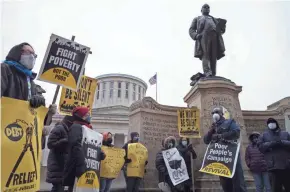  ?? JOSHUA A. BICKEL/COLUMBUS DISPATCH ?? The Rev. Samuel Prince, bottom right, of the St. Paul Angelican Church in Fairfield, Connecticu­t, speaks during a rally with the Ohio Poor People’s Campaign in March at the Ohio Statehouse in Columbus. The group was advocating for many things, including a raising of the minimum wage, a fuller COVID-19 relief bill, more affordable health care and voting rights.