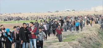  ?? ADEL HANA THE ASSOCIATED PRESS ?? Protesters walk toward the Gaza Strip border fence with Israel Friday during a rally east of Gaza City. Hamas kept border protests widely restrained, reports said.