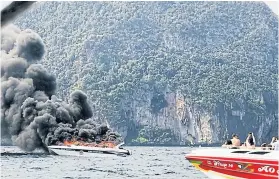  ?? KRABI DISASTER PREVENTION AND MITIGATION OFFICE ?? Black smoke billows from a speedboat after a blast caused by an oil leak near Koh Phi Phi Le in Krabi province, injuring 16 Thais and Chinese.