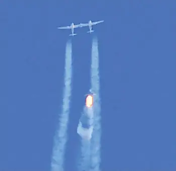  ?? PATRICK T. FALLON / AFP VIA GETTY IMAGES ?? The Virgin Galactic spaceship Unity, with entreprene­ur Richard Branson and three passengers aboard, separates
from the mother ship above a base in New Mexico on Sunday on its way to the edge of space.