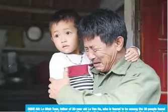  ??  ?? NGHE AN: Le Minh Tuan, father of 30-year old Le Van Ha, who is feared to be among the 39 people found dead in a truck in Britain, cries while holding Ha’s son outside their house in Vietnam’s Nghe An province yesterday. —AFP