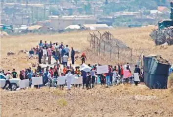  ?? AFP ?? Displaced Syrians from Dara’a stage a protest calling for internatio­nal protection in the Syrian village of Al Rafid, near the fence with Israeli-annexed Syrian Golan Heights.