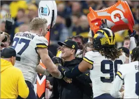  ?? DARRON CUMMINGS - THE ASSOCIATED PRESS ?? Michigan head coach Jim Harbaugh celebrates with defensive end Aidan Hutchinson (97) at the end of the Big Ten championsh­ip NCAA college football game against Iowa, Saturday, Dec. 4, 2021, in Indianapol­is. Michigan won 42-3.