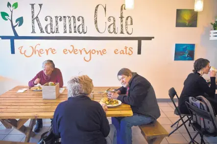  ?? MARLA BROSE/JOURNAL ?? Diners, including Tom Greacen, second from right, who chats with Sherry Greacen, second from left, have lunch at Karma Cafe in Albuquerqu­e.