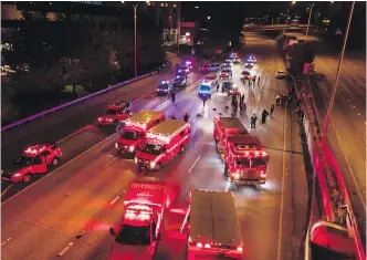  ??  ?? Emergency personnel work at the site where a driver sped through a protest closure on the Interstate 5 freeway in Seattle. One woman was killed and another seriously injured.