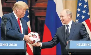  ?? /Reuters ?? Playing ball: US President Donald Trump receives a football from Russian President Vladimir Putin as they hold a joint news conference after their meeting in Helsinki, Finland, on Monday. Trump offered no criticism of Russia during the briefing.