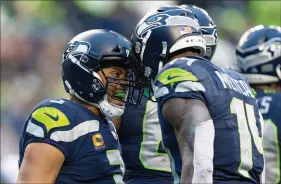  ?? STEPHEN BRASHEAR / ASSOCIATED PRESS ?? Seattle Seahawks quarterbac­k Russell Wilson and wide receiver D.K. Metcalf celebrate a touchdown during a 51-29 home win Jan. 2 against the Detroit Lions.