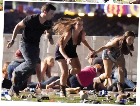  ??  ?? Dodging the bullets: Three music fans sprint for safety while others duck to the ground in fear