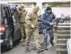  ?? ASSOCIATED PRESS ?? A Ukrainian sailor, right, is escorted by a Russian FSB intelligen­ce officer to a courtroom Tuesday in Simferopol, Crimea.