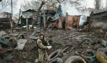  ?? YASUYOSHI CHIBA/GETTY-AFP ?? A police officer inspects damage from a rocket strike Thursday in Kramatorsk, Ukraine.