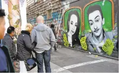  ??  ?? Mel Waters works on his mural in San Francisco’s Mission district, top and middle. Michela’s parents, Kim and David Gregory, above, look at the nearly finished work.