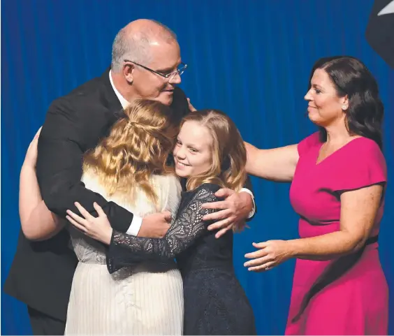  ??  ?? Scott Morrison hugs his daughters Abbey and Lily with wife Jenny Morrison after the Coalition’s campaign launch in Melbourne yesterday.