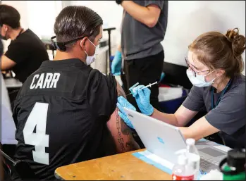  ?? CHRISTOPHE­R DEVARGAS FILE ?? A Las Vegas Raiders fan receives a COVID-19 vaccinatio­n Sept. 13 before entering Allegiant Stadium.